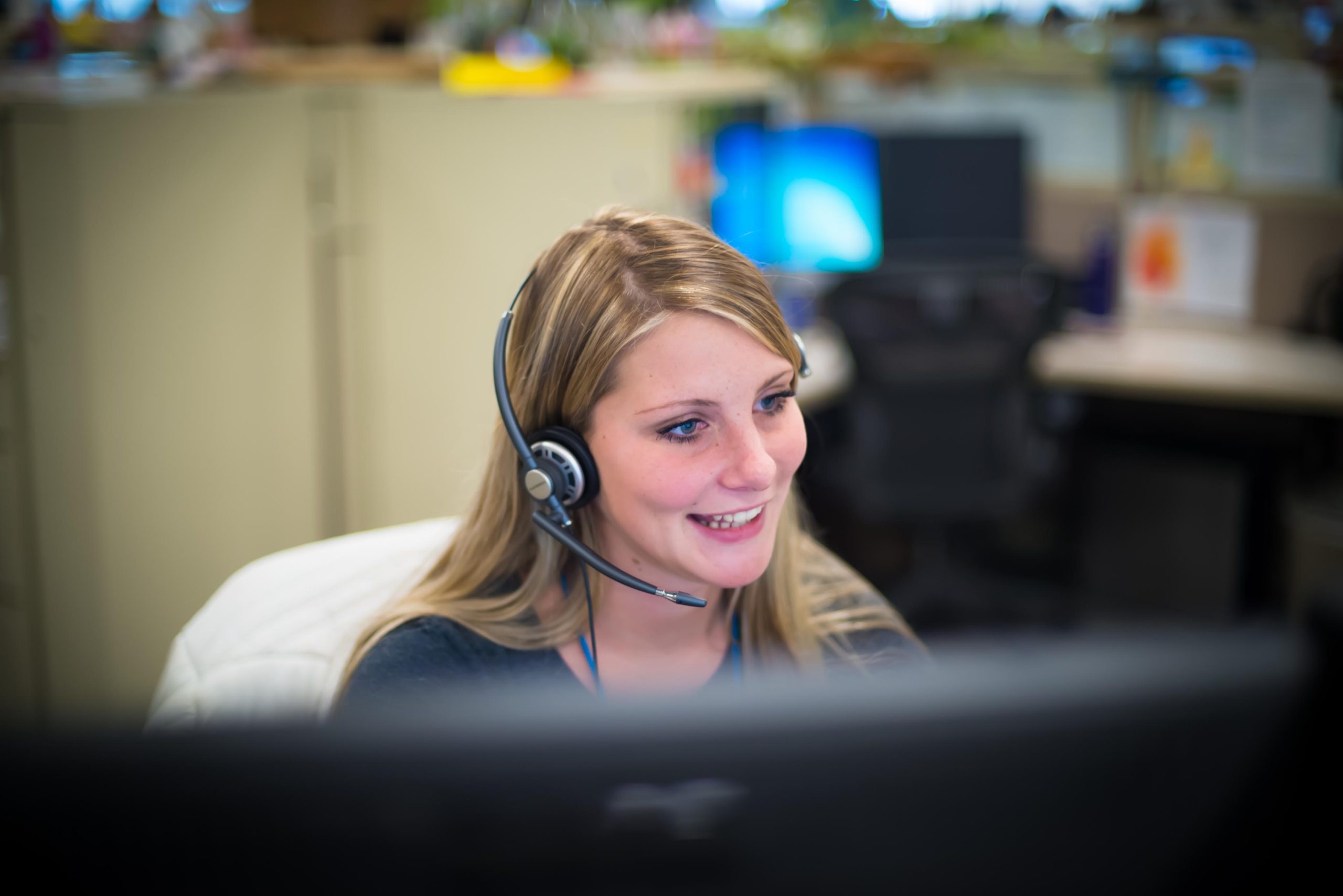 Female employee at a computer answering a call