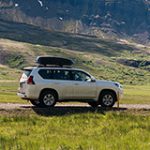 Car driving on a dirt road in a scenic setting